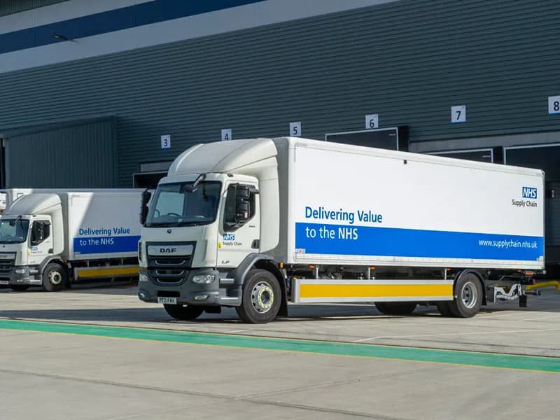 NHS Supply Chain DAF LF box trucks parked at a distribution centre loading bays