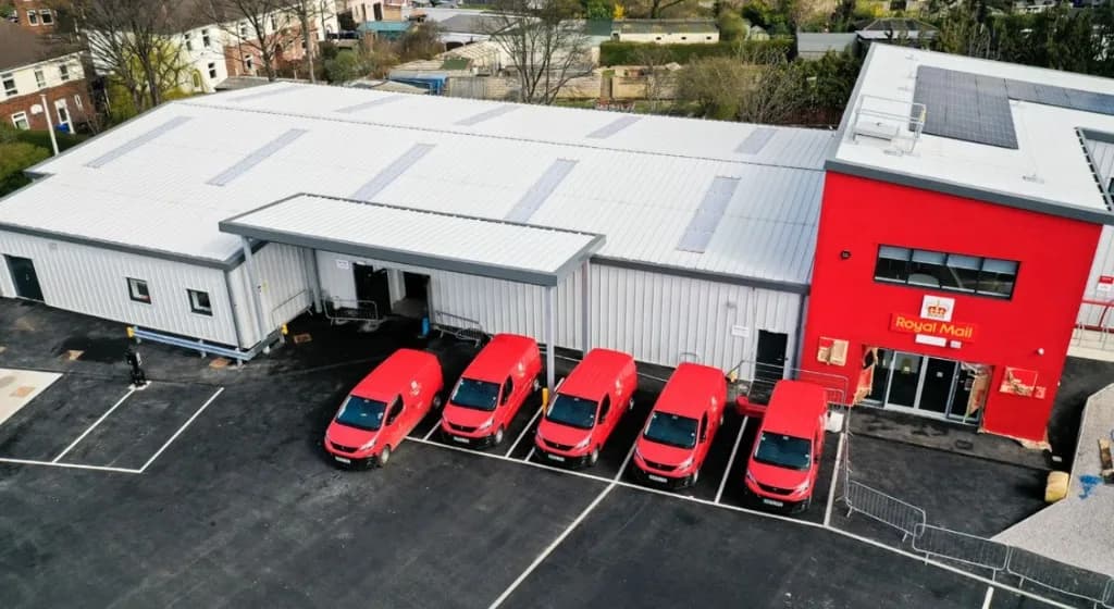 Royal Mail last-mile delivery vans parked under a covered bay at a modern depot from Dynamon ZERO electrification case study