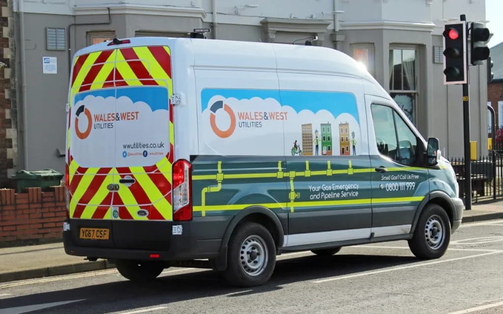 White Wales & West Utilities gas emergency van with red and yellow chevrons parked on a residential street