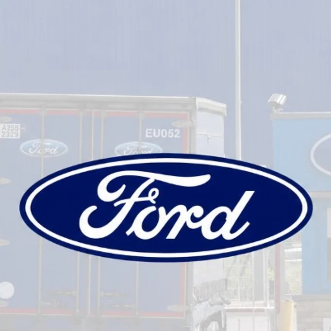 Ford-liveried articulated lorry leaving the main vehicle gate of a Ford manufacturing plant