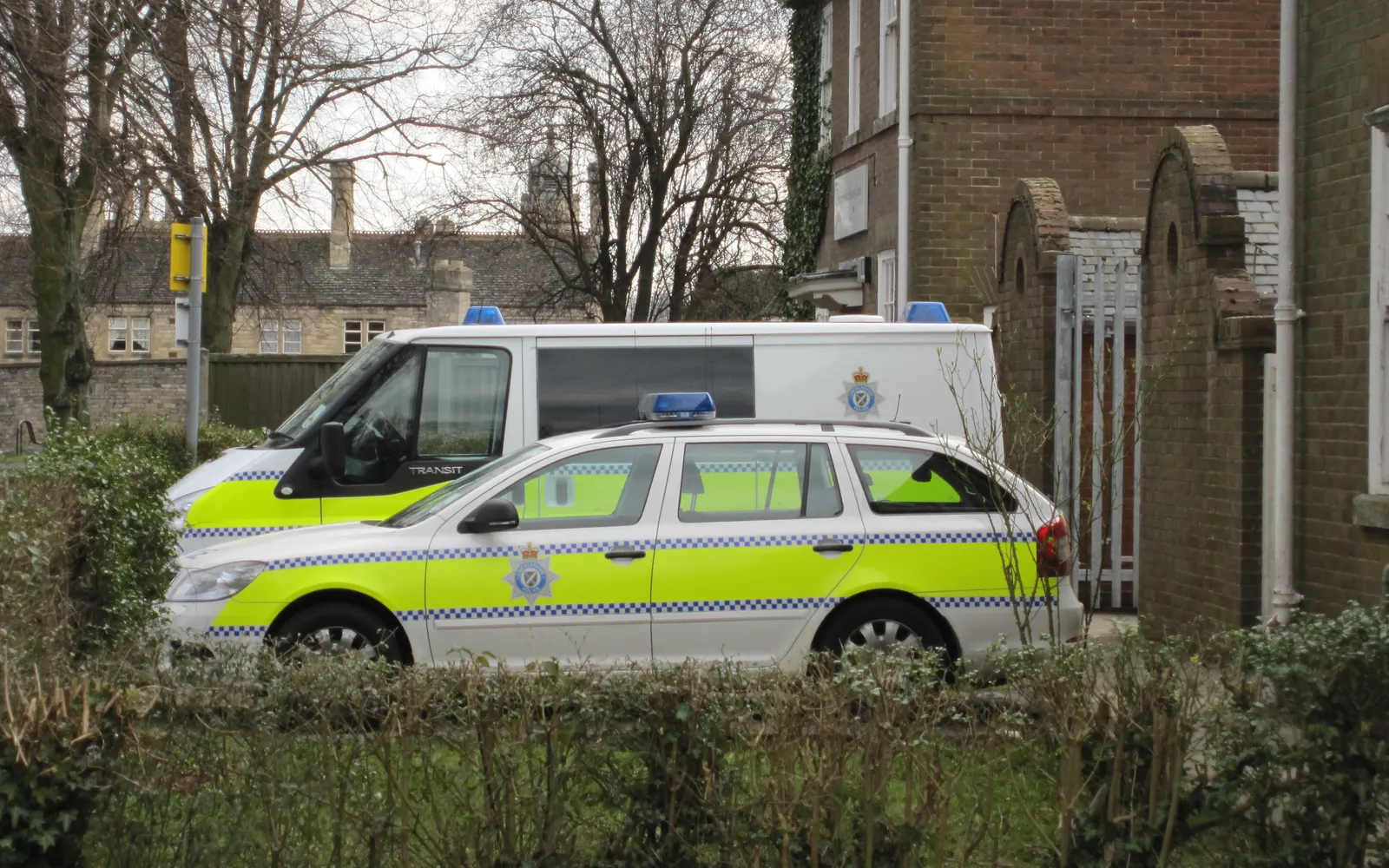 Marked Lincolnshire Police estate car and Ford Transit van in yellow and blue battenburg markings at Stamford police station — photo by Bob Harvey, CC BY-SA 2.0